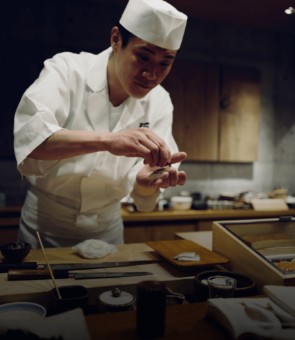 Restaurant Chef cooking and preparing fresh Sushi
