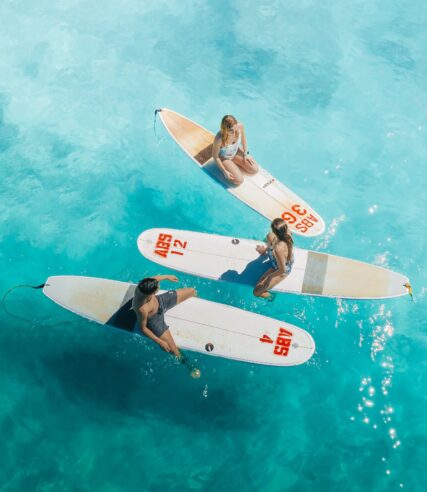 Three people on surfboards in the water.