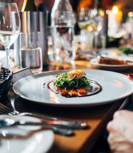 a plate of food and a glass of wine on a table.