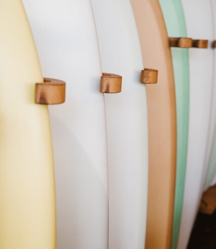 Various colored surfboards neatly displayed on a stand.