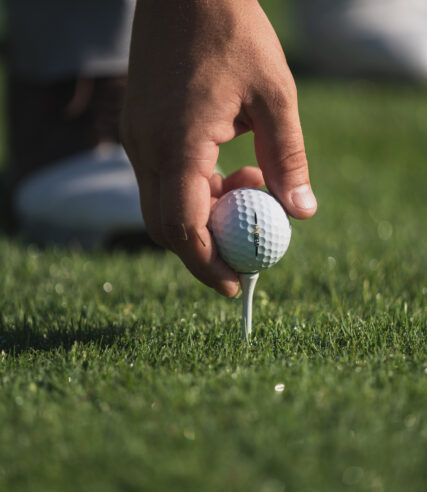 A man putting a golf ball into a position.